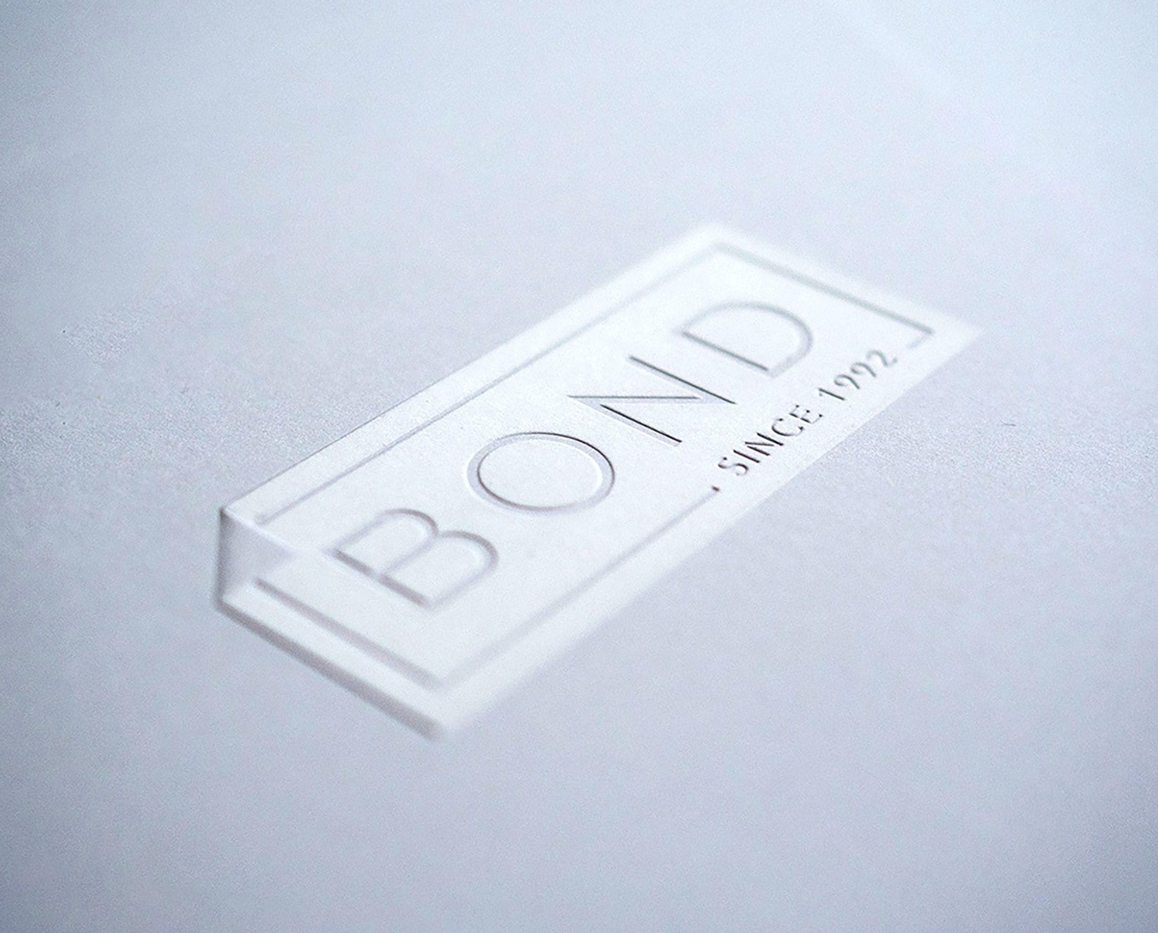 Custom finishing services - embossing Bond Reproductions logo.