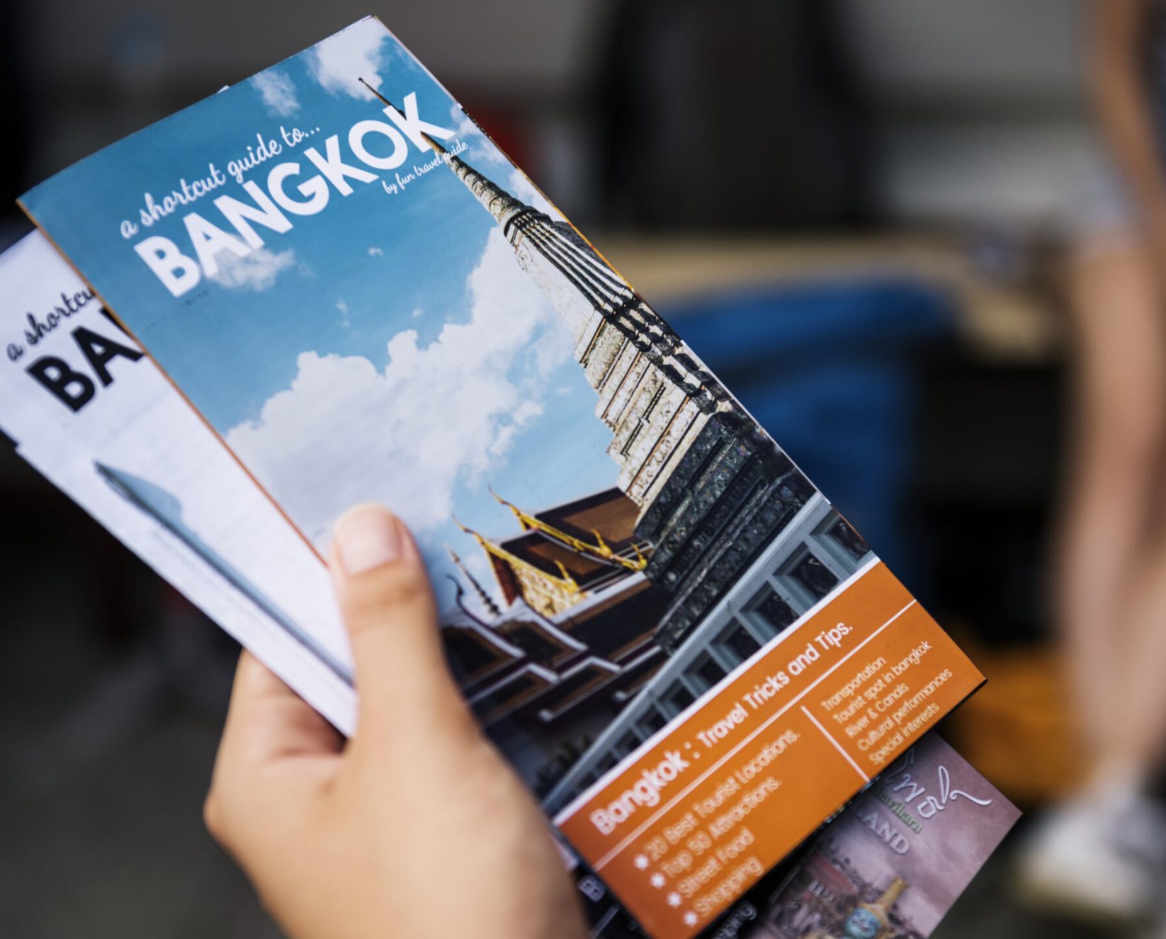 Closeup,Of,Hand,Holding,Bangkok,Travel,Guide,Brochure